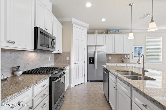 kitchen featuring pendant lighting, sink, ornamental molding, white cabinetry, and stainless steel appliances