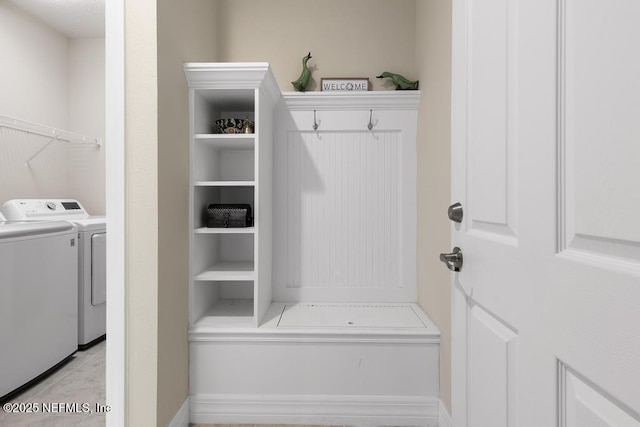 clothes washing area featuring washing machine and dryer and light tile patterned flooring