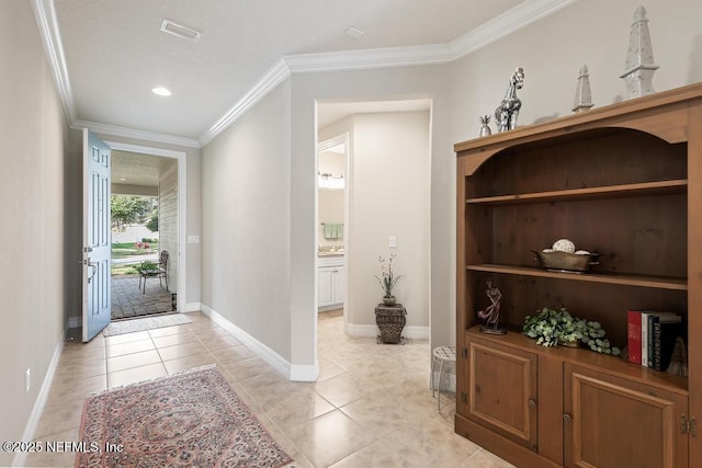 entryway with light tile patterned floors and crown molding