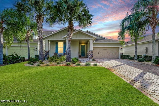 view of front of property featuring a porch, a garage, and a yard