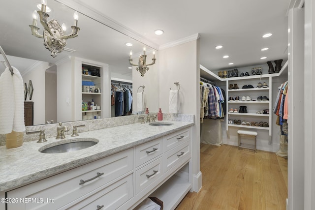 bathroom with ornamental molding, hardwood / wood-style flooring, and vanity