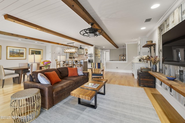 living room featuring light hardwood / wood-style floors, ornamental molding, beam ceiling, and ceiling fan