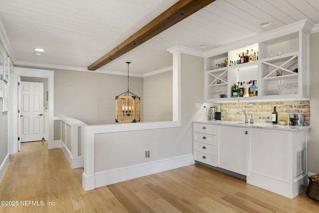 bar featuring crown molding, light hardwood / wood-style floors, white cabinetry, beam ceiling, and pendant lighting