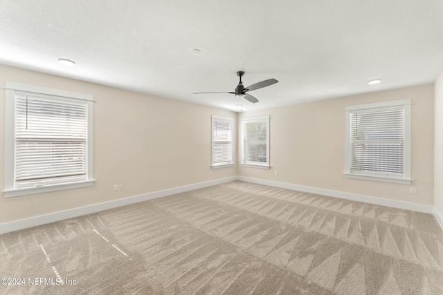 unfurnished room with ceiling fan and light colored carpet