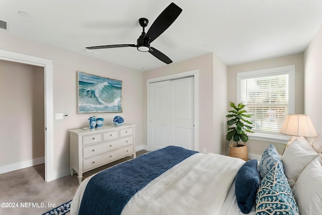 bedroom with a closet, ceiling fan, and light colored carpet