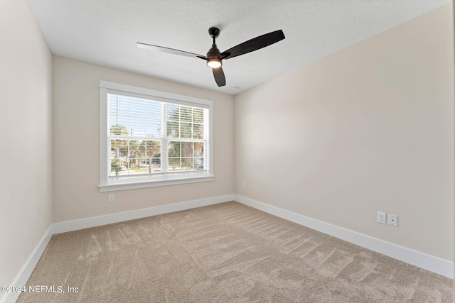 unfurnished room with ceiling fan, light colored carpet, and a textured ceiling