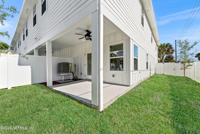 rear view of house with ceiling fan, cooling unit, a patio area, and a yard