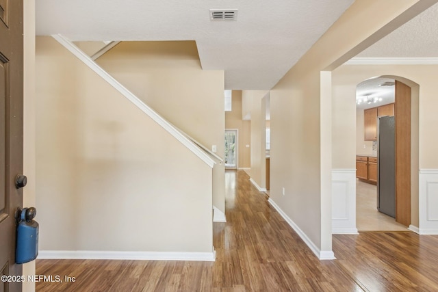 foyer featuring a textured ceiling, hardwood / wood-style flooring, and ornamental molding