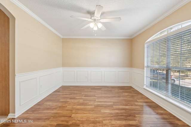 empty room with ceiling fan, a healthy amount of sunlight, light wood-type flooring, and ornamental molding