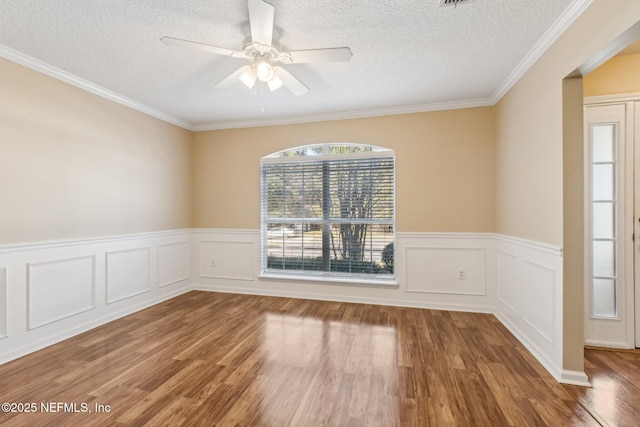 spare room with wood-type flooring, a textured ceiling, ceiling fan, and crown molding