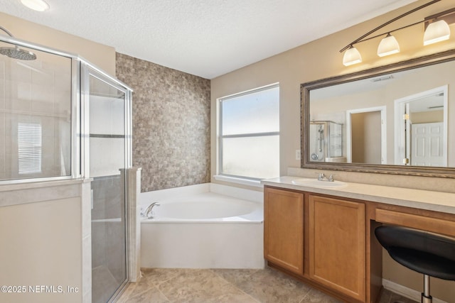 bathroom featuring vanity, plus walk in shower, and a textured ceiling