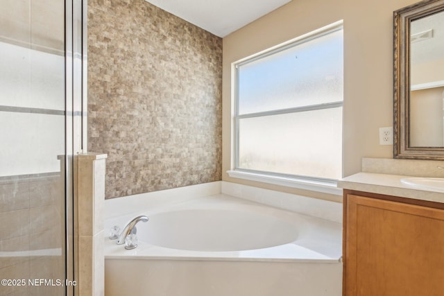 bathroom with a wealth of natural light, vanity, and independent shower and bath