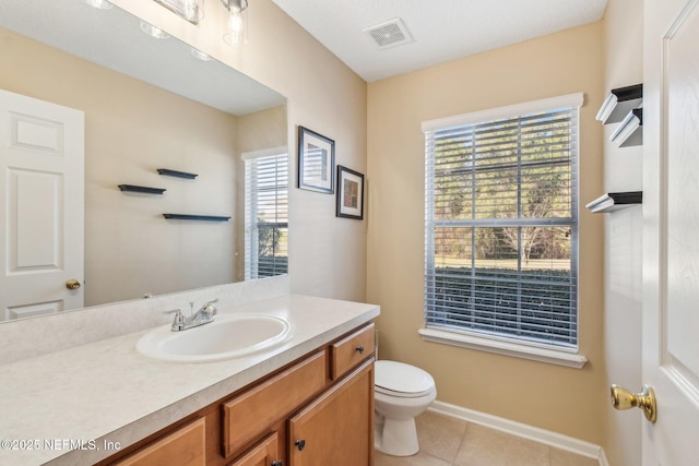 bathroom with tile patterned floors, vanity, toilet, and plenty of natural light