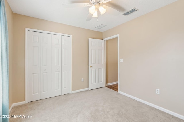 unfurnished bedroom featuring ceiling fan, a closet, and light colored carpet