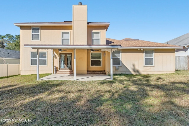 rear view of house with french doors, ceiling fan, a patio area, and a lawn