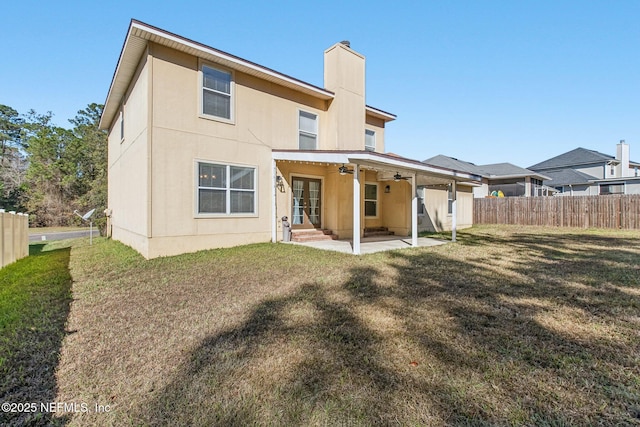 back of property featuring a lawn and a patio