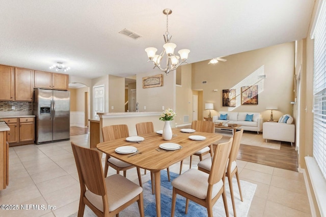 tiled dining room with a chandelier, a textured ceiling, and plenty of natural light