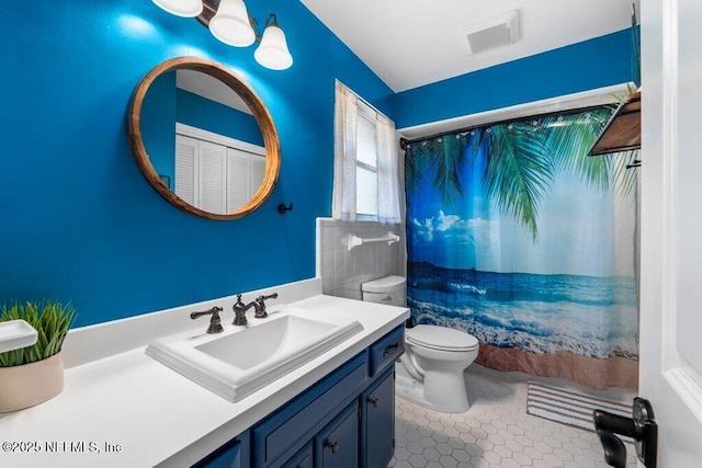 bathroom featuring tile patterned flooring, vanity, toilet, and walk in shower