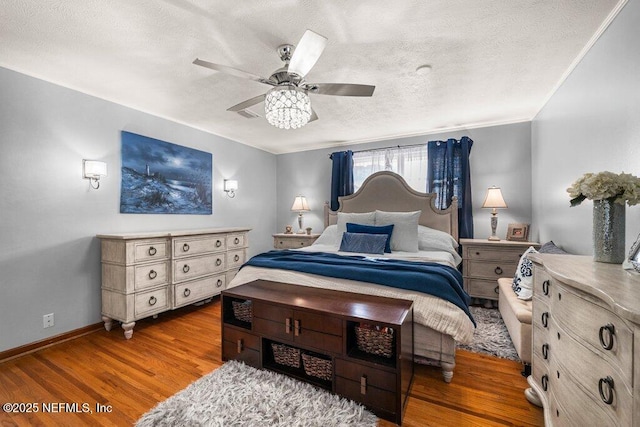 bedroom with a textured ceiling, dark hardwood / wood-style floors, and ceiling fan