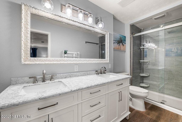 bathroom featuring walk in shower, toilet, vanity, and hardwood / wood-style flooring