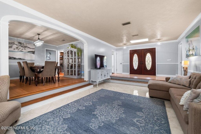 living room featuring light tile patterned floors and ornamental molding