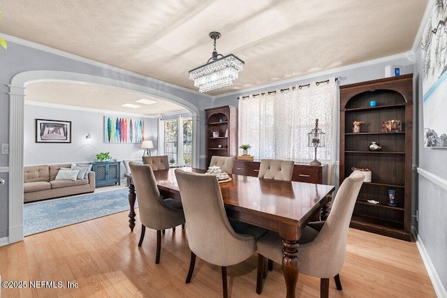 dining space with a textured ceiling, a notable chandelier, and crown molding