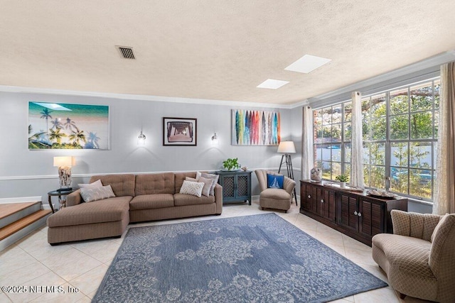 living room with a wealth of natural light, light tile patterned floors, a textured ceiling, and ornamental molding