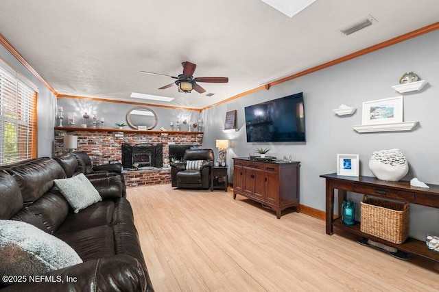 living room with light hardwood / wood-style floors, a wood stove, and ornamental molding