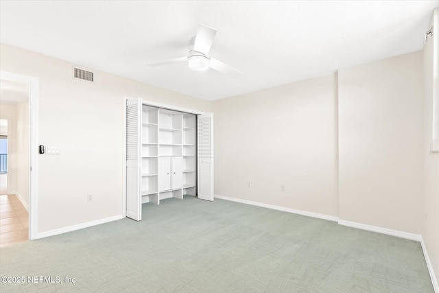 unfurnished bedroom with ceiling fan, a closet, and carpet floors