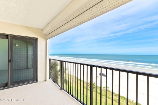 balcony with a water view and a beach view