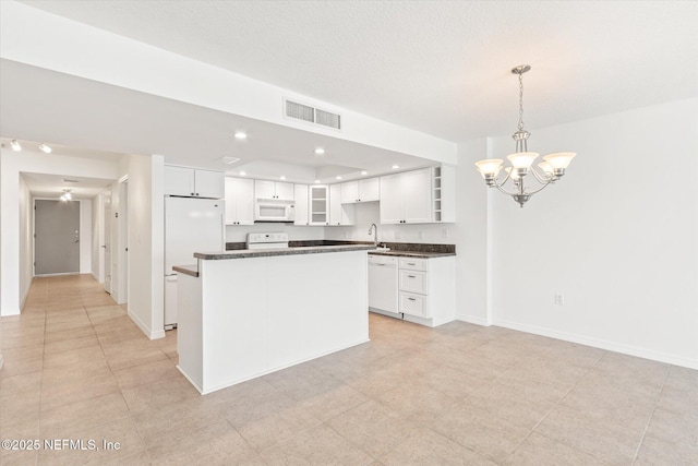 kitchen with white appliances, decorative light fixtures, a chandelier, a center island, and white cabinetry