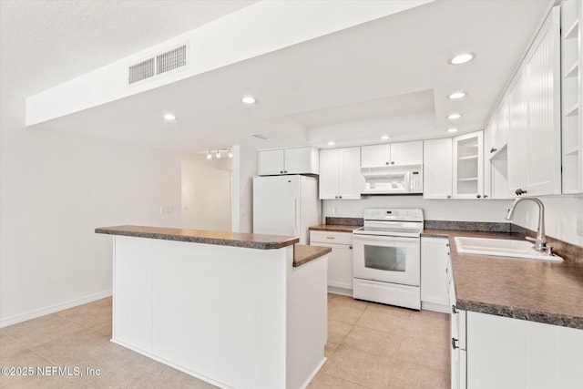 kitchen with white appliances, a kitchen island, sink, white cabinetry, and light tile patterned flooring