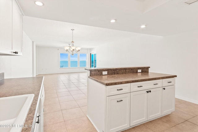 kitchen featuring a chandelier, light tile patterned floors, decorative light fixtures, and white cabinetry