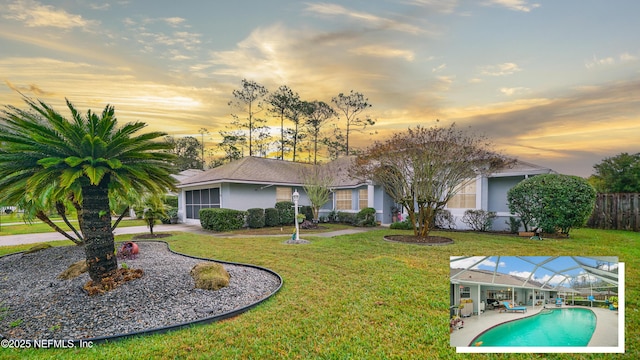 exterior space with a lanai, a fenced in pool, a yard, and a patio