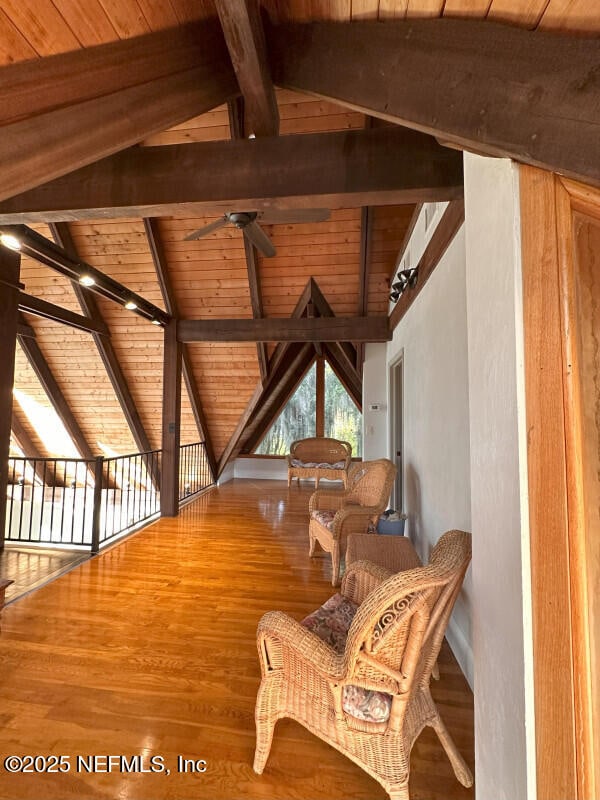 living area with lofted ceiling with beams, ceiling fan, wooden ceiling, and wood-type flooring