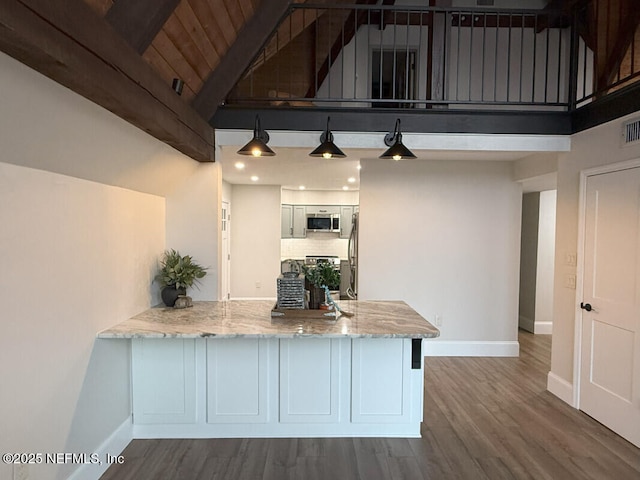 kitchen with beamed ceiling, kitchen peninsula, hardwood / wood-style flooring, and wooden ceiling