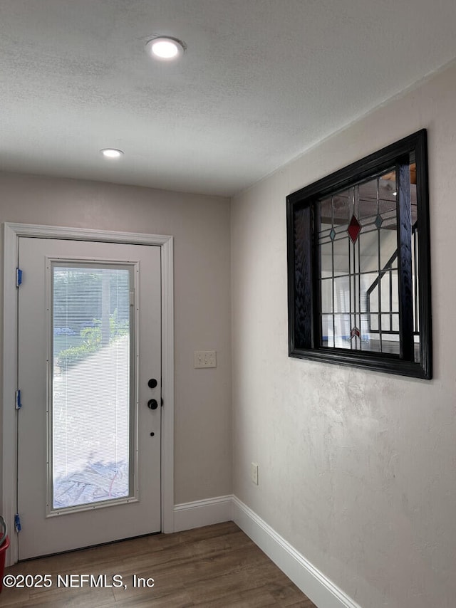 doorway with hardwood / wood-style flooring and a textured ceiling