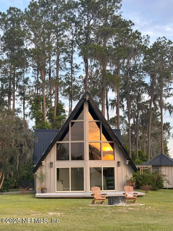 rear view of house featuring a yard