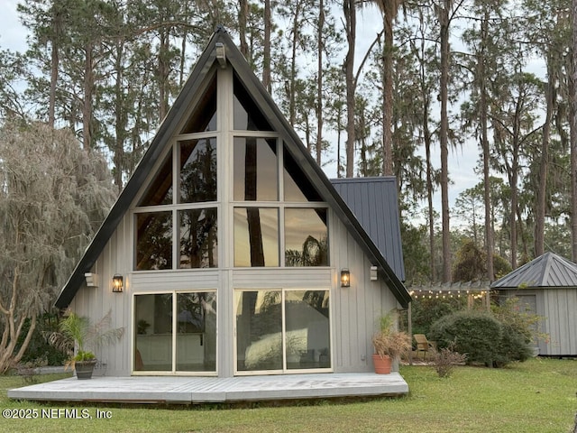 back of house with a lawn and an outdoor structure