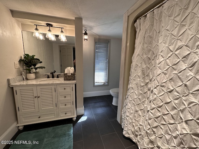 bathroom featuring vanity, a textured ceiling, and toilet