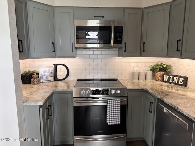 kitchen featuring gray cabinetry, decorative backsplash, and appliances with stainless steel finishes