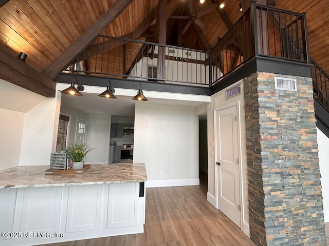 kitchen with beam ceiling, white cabinetry, high vaulted ceiling, stainless steel range with electric cooktop, and wood ceiling