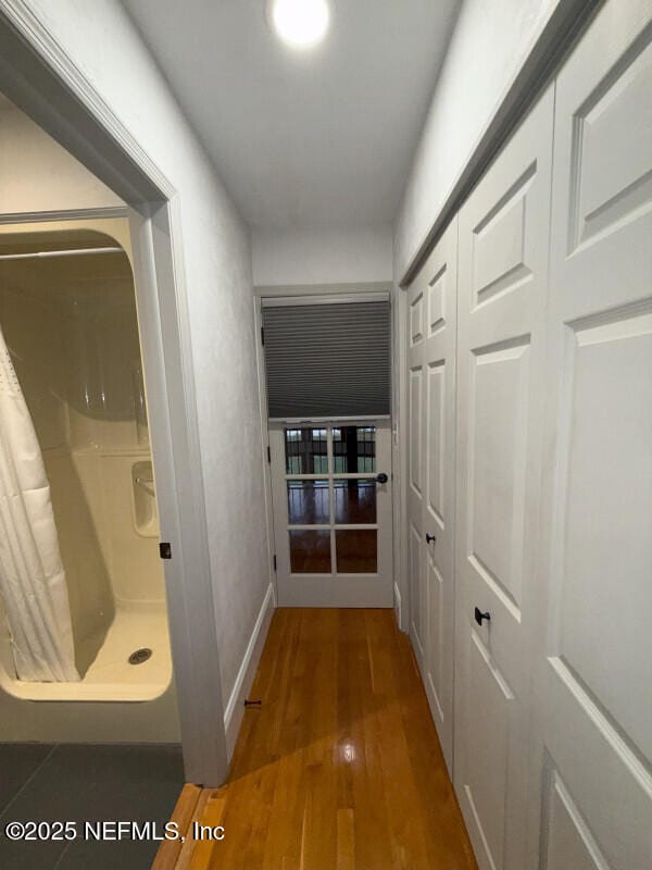 corridor with dark wood-style floors and baseboards