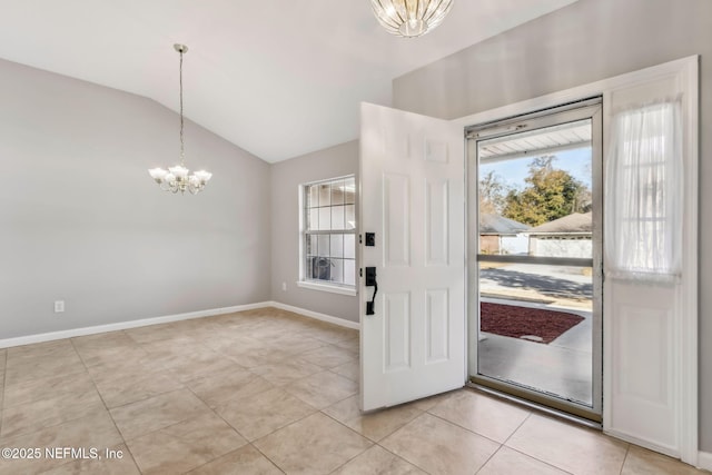 tiled entrance foyer with lofted ceiling and a notable chandelier