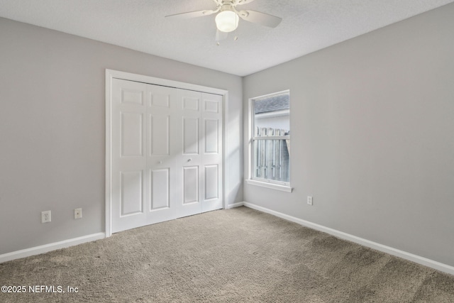unfurnished bedroom with ceiling fan, carpet flooring, a closet, and a textured ceiling
