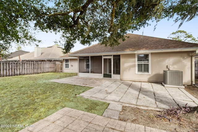 back of house featuring a patio area, a sunroom, central air condition unit, and a lawn