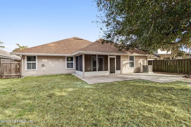 rear view of house featuring a sunroom, a yard, a patio area, and central air condition unit
