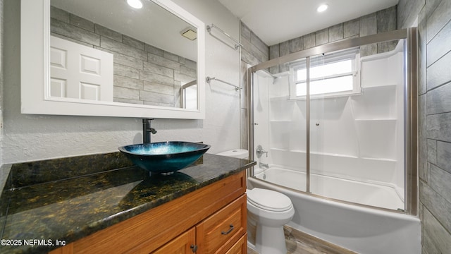 full bathroom with wood-type flooring, vanity, toilet, and bath / shower combo with glass door