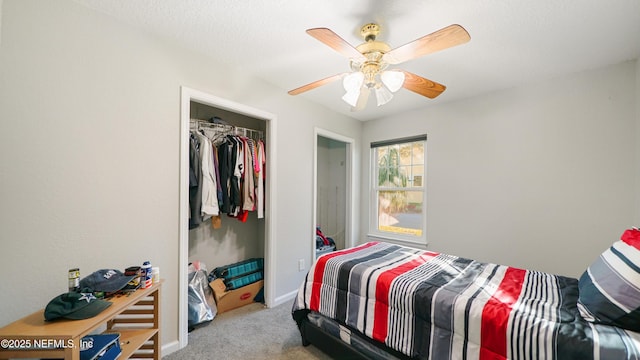 carpeted bedroom with ceiling fan and a closet