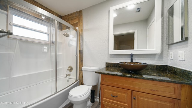 full bathroom with vanity, toilet, and enclosed tub / shower combo